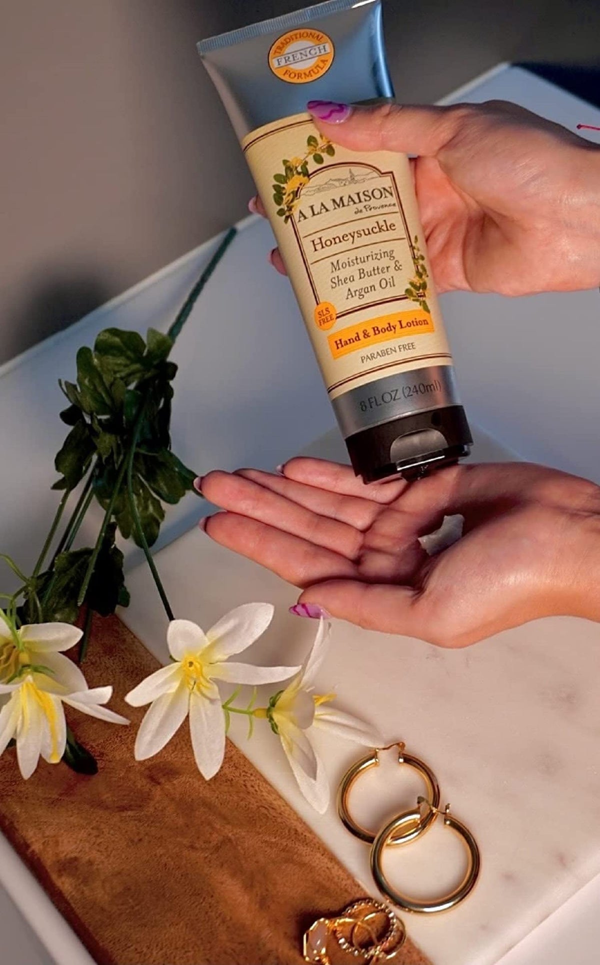 A LA MAISON honeysuckle dispensing pump in use demonstrating easy application and non-greasy feel