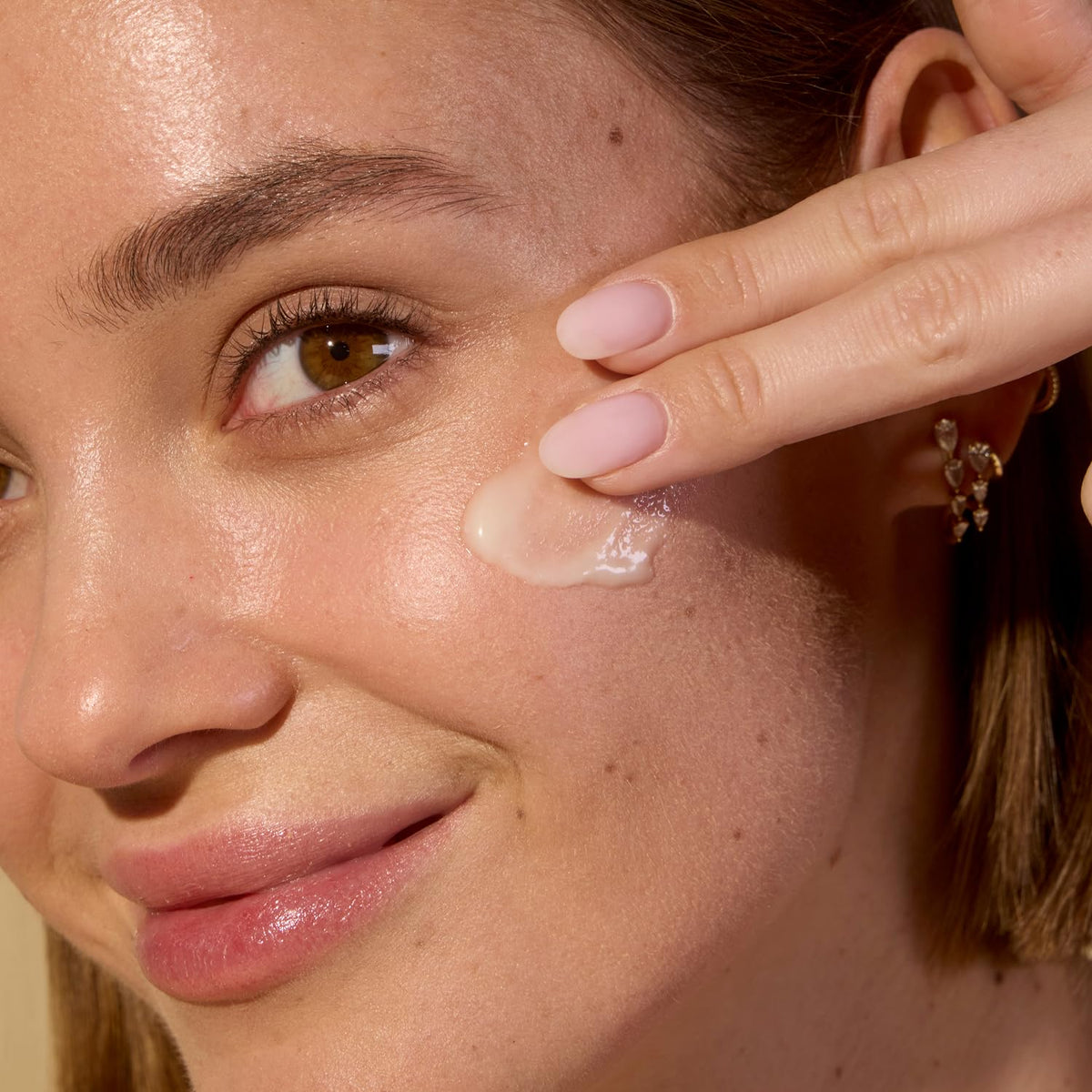 Acure cream being applied to cheek demonstrating gentle hydration benefit