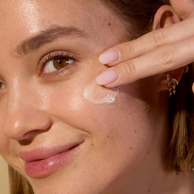 Acure cream being applied to cheek demonstrating gentle hydration benefit