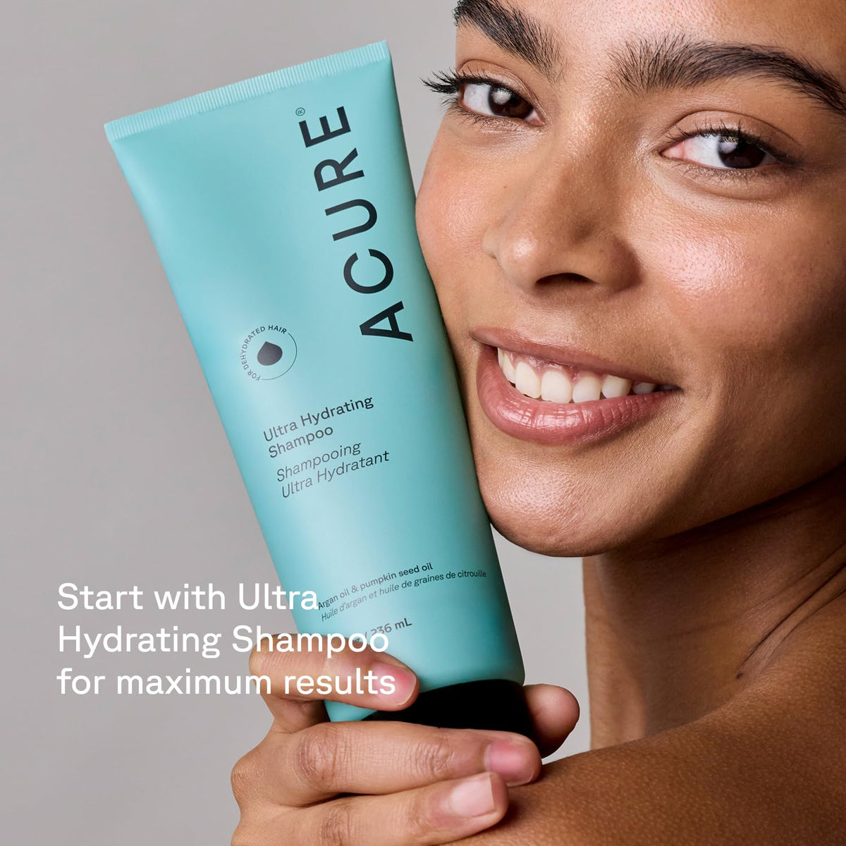 Acure 8 fl oz bottle next to everyday items conveying true size and portability
