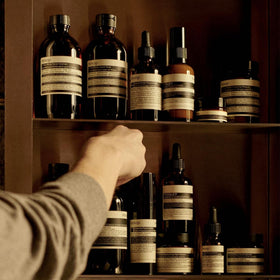 Aesop 200 mL bottle beside everyday items showing travel-friendly scale benefit