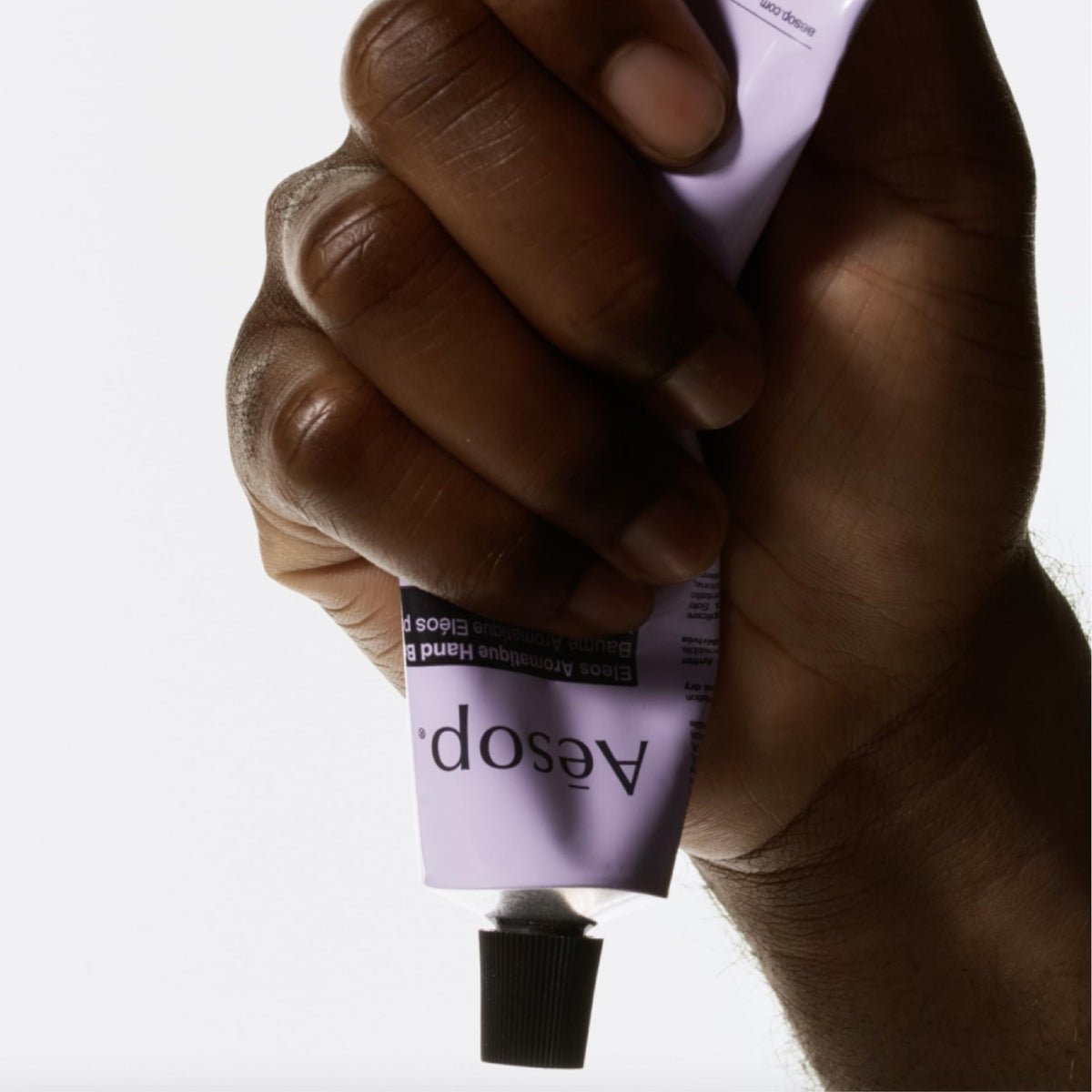 Aesop Eleos tube beside a passport showing compact travel size convenience