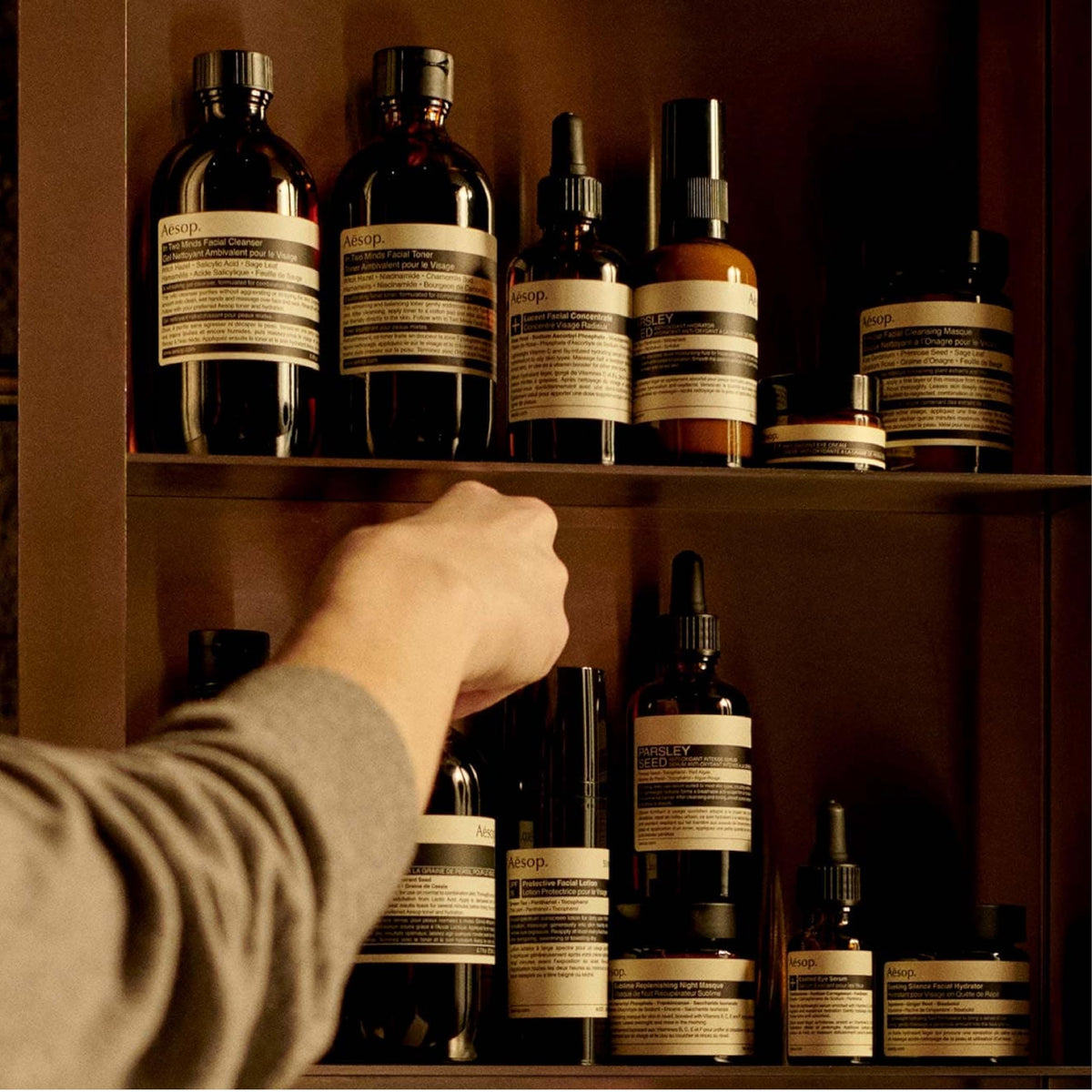 Hand applying Aesop balm to forearm, demonstrates lightweight hydration benefit