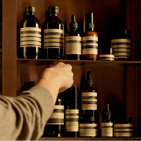 Hand applying Aesop balm to forearm, demonstrates lightweight hydration benefit
