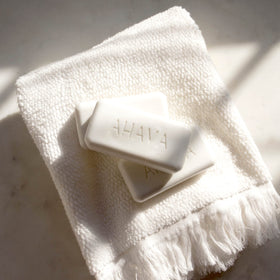 AHAVA lathered Dead Sea Salt Soap in hand demonstrating gentle cleansing foam