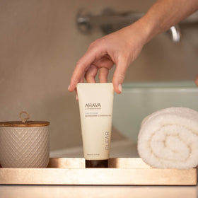 AHAVA cleanser beside hand for size comparison and easy travel benefit