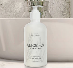 Alice + Co. size comparison in hand illustrating travel-friendly 8.5 oz bottles