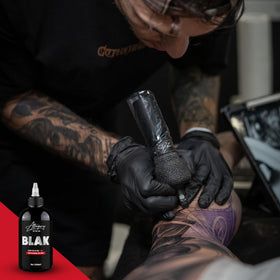 Artist using Allegory BLAK in hand while lining a tattoo demonstrating precise flow control