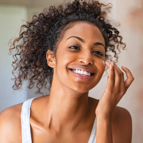 Amazon Basics applying serum on hand to show smooth absorption and benefit