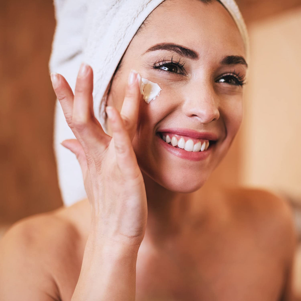 Applying Amazon Basics night cream to cheek to demonstrate easy absorption benefit