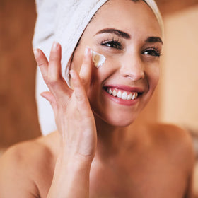 Applying Amazon Basics night cream to cheek to demonstrate easy absorption benefit