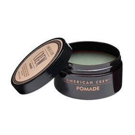 American Crew pomade texture close-up on finger demonstrating smooth, water-based consistency