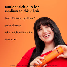 amika shampoo 275ml bottle beside hand for size and everyday convenience
