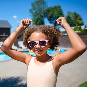 Child having AQUA GUARD applied to damp hair before swimming