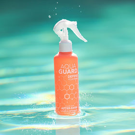 AQUA GUARD bottle held in hand to show travel size and portability