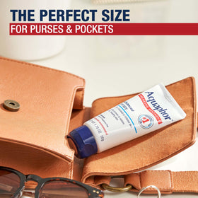 Aquaphor tube next to a credit card to illustrate compact travel size