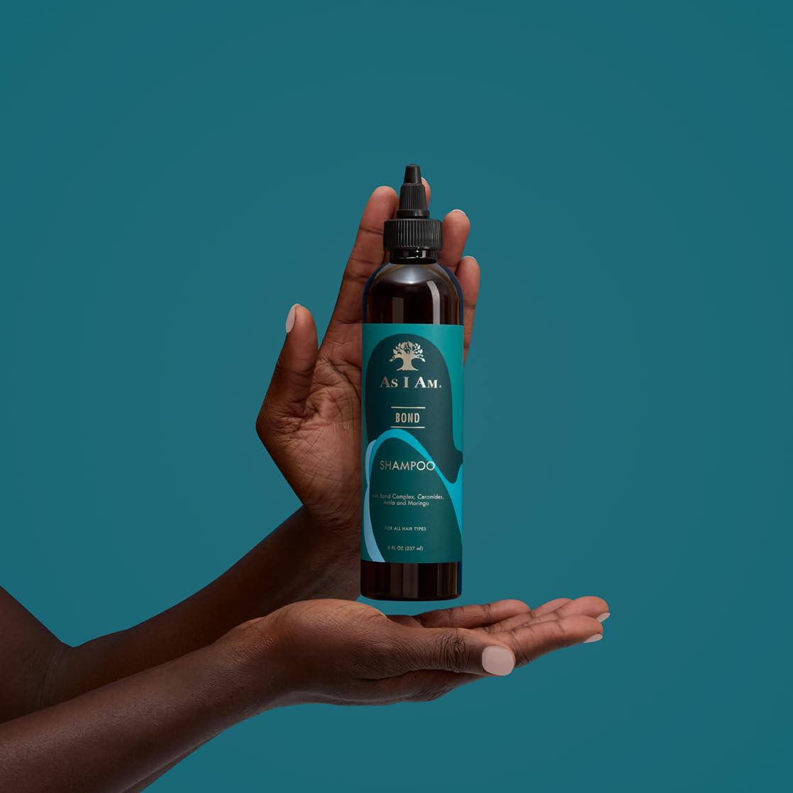 As I Am bottle held in hand for scale showing compact 8 oz travel-friendly size