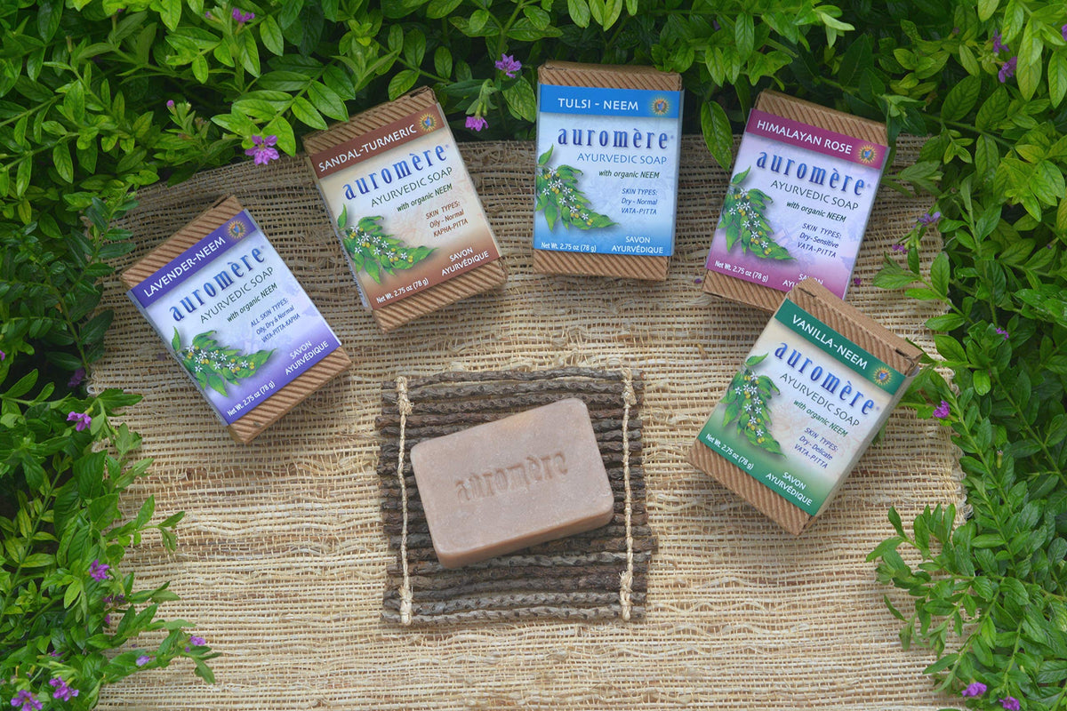 Auromere sandal turmeric soap held in hand for size comparison and travel convenience
