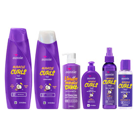 Lifestyle shot of woman applying Aussie Miracle Curls for frizz-free definition