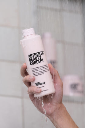 Authentic Beauty Concept bottle held in hand showing size and travel-friendly benefit