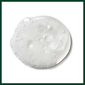Hand holding Aveda bottle to show 6.7 fl oz scale, conveys travel-friendly and lightweight