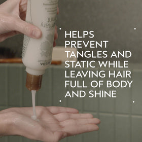 Aveda back label close-up displaying Rosemary Mint conditioner ingredients and usage information