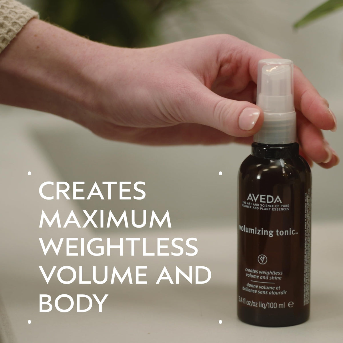 Aveda volumizing hair tonic mid-air spray action demonstrating fine mist lift
