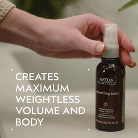Aveda volumizing hair tonic mid-air spray action demonstrating fine mist lift
