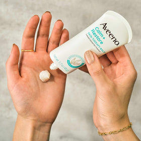 Aveeno balm being applied to cheek to soothe dry, sensitive skin