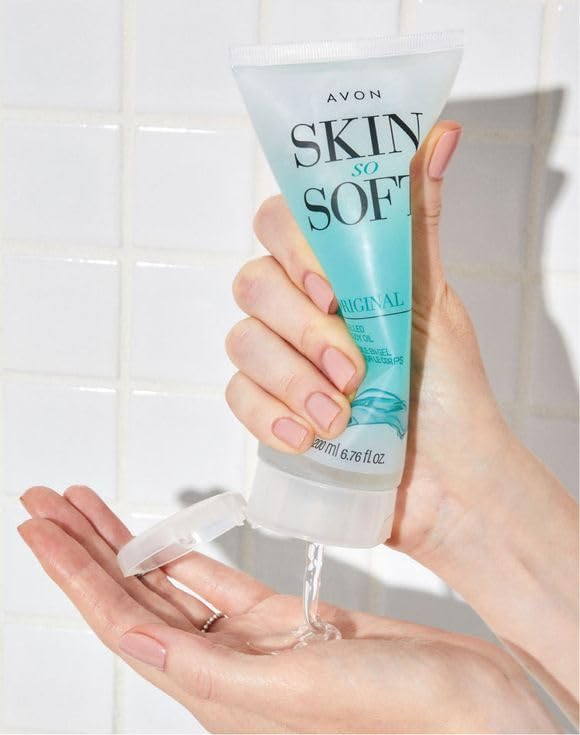 AVON Skin So Soft tube next to a hand showing compact 6.76 fl oz size for travel convenience