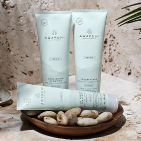 Stylist applying Awapuhi Wild Ginger in salon highlighting Paul Mitchell professional smoothing result