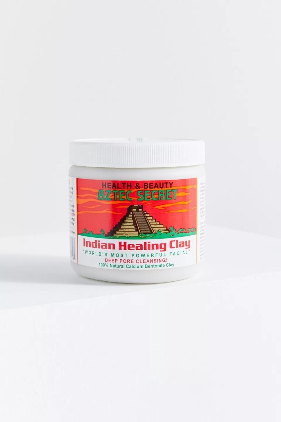 Person applying Aztec Secret mask in spa-like setting for refreshed skin