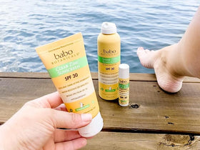 Babo Botanicals 3 fl oz bottle beside sunglasses illustrating travel size