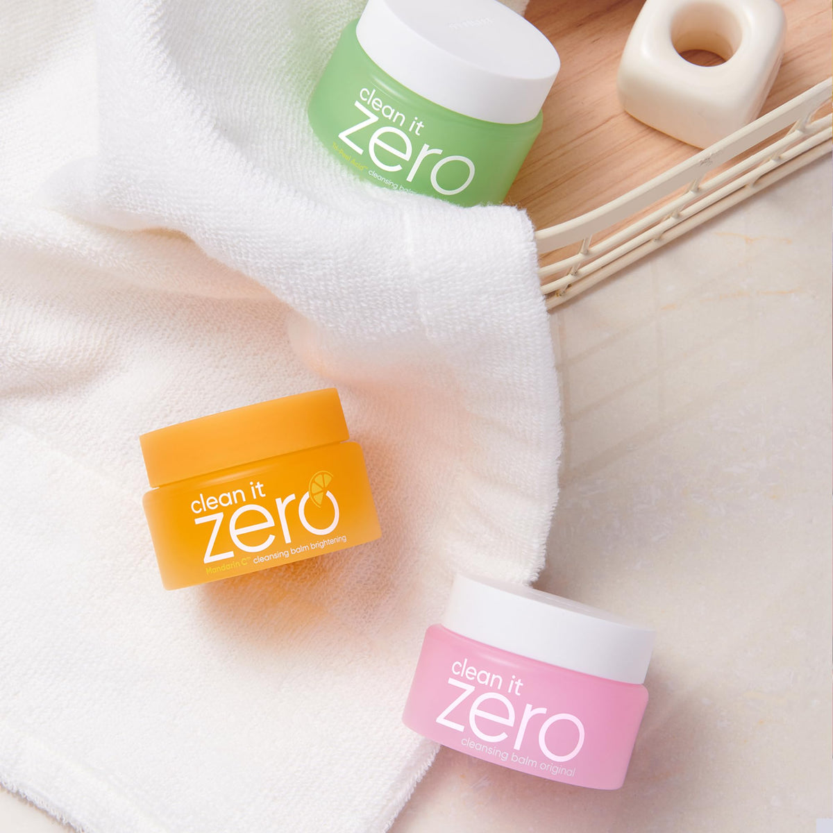 BANILA CO travel-size jars in hand to show scale and portability for on-the-go cleansing
