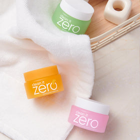 BANILA CO travel-size jars in hand to show scale and portability for on-the-go cleansing