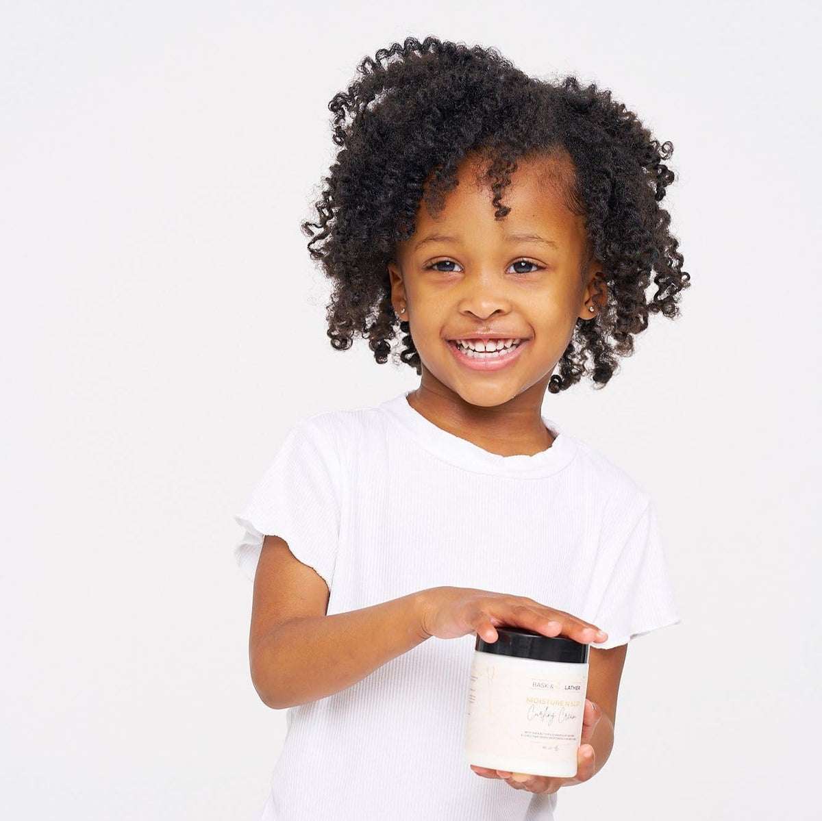 BASK & LATHER applied in curly hair during styling for defined bounce and reduced frizz