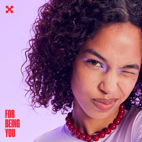 BEING INC lifestyle image of a curly-haired model smiling with defined curls