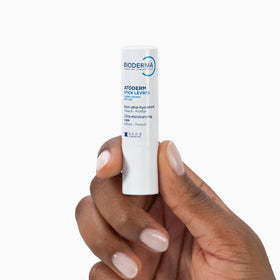 Bioderma Atoderm lip stick in outdoor setting illustrating on-the-go hydration and protection