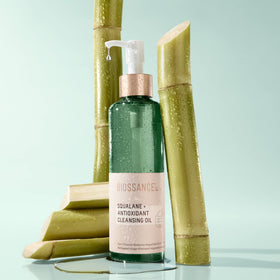 Biossance bottle beside hand showing true size and travel-ready benefit