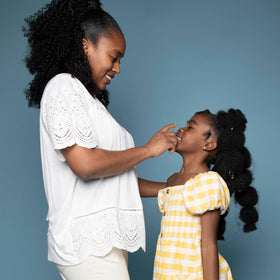 black girl sunscreen held in hand for 6 fl oz size comparison