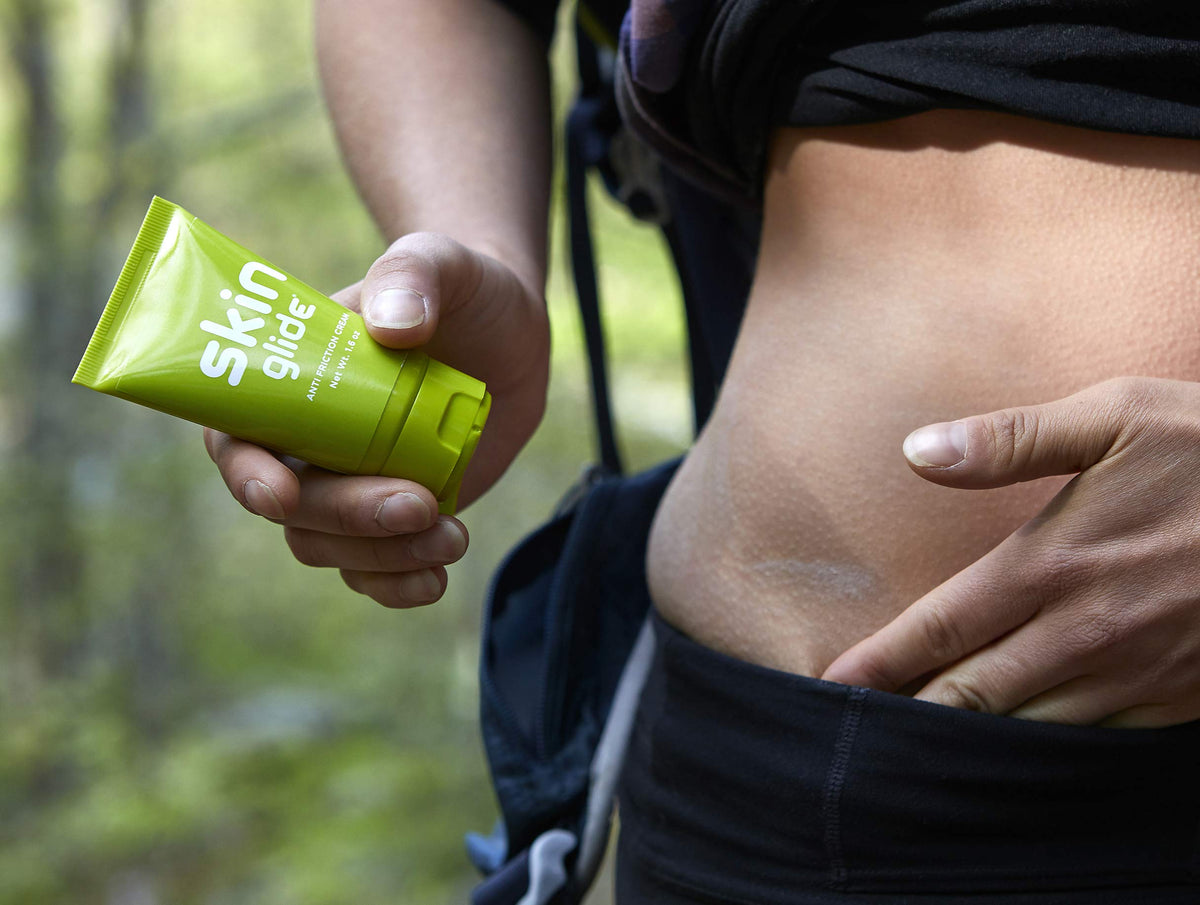 Runner applying BodyGlide to hip area showing chafe prevention during runs