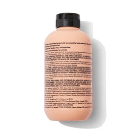 Bondbar clarifying shampoo in bathroom setting beside towel, demonstrates use for removing buildup