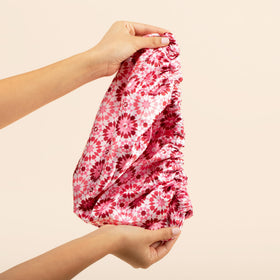 Bounce Curl bonnet shown with hand for size comparison ensuring roomy fit benefit