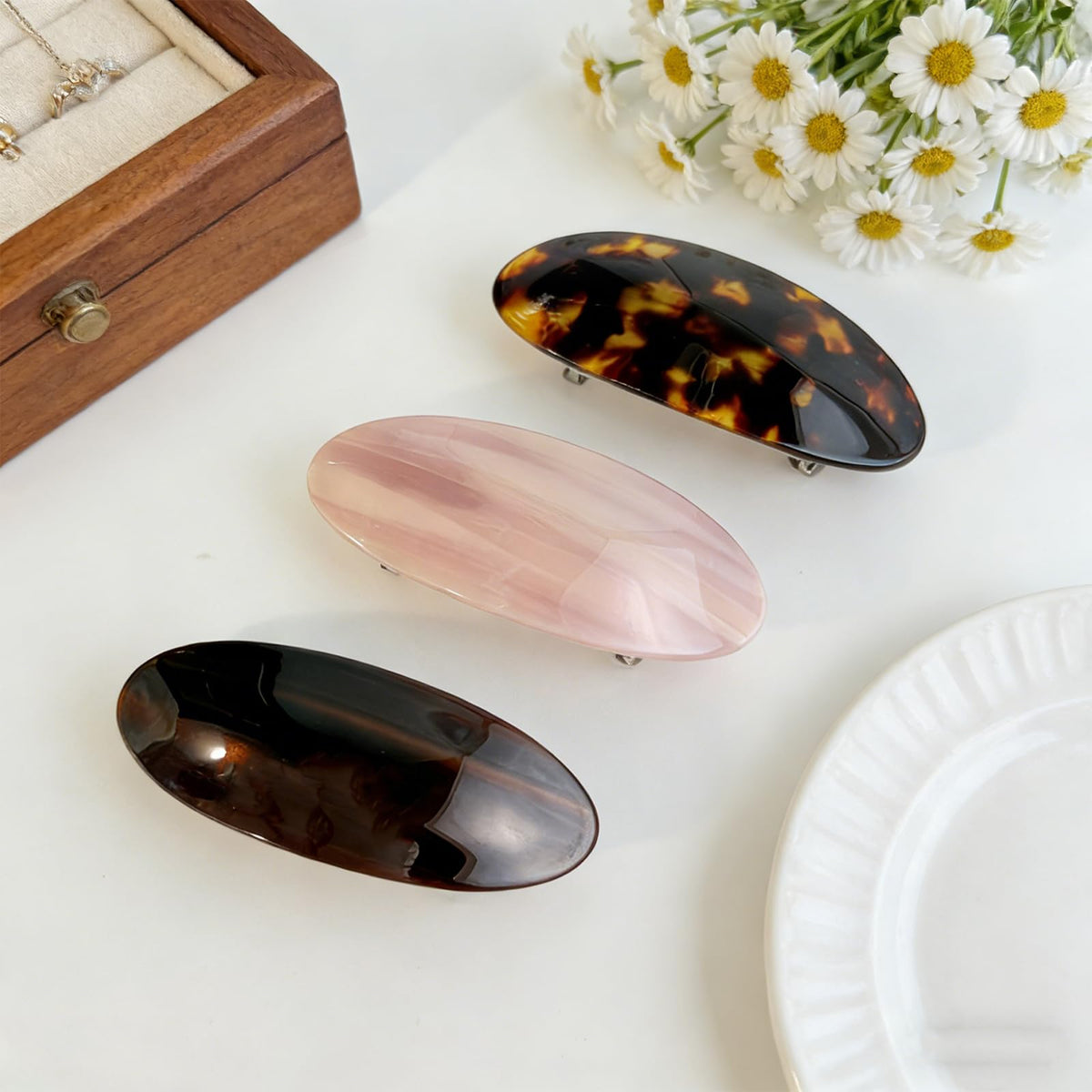 BOUNIQ barrette held in hand to show 3.5 inch scale, clear size reference