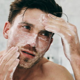 Brickell men's acne face wash next to common items showing 6 ounce size