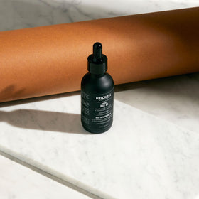 Brickell Men's Argan Oil being applied to hair to tame frizz and add shine