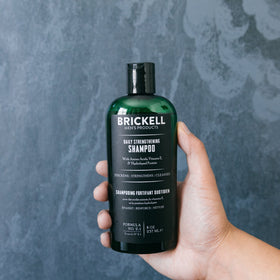 Brickell Men's Products bottle held in hand to show compact 8oz travel-friendly benefit