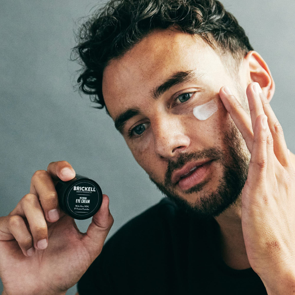 Brickell Men's Products eye cream application on under-eye area showing targeted brightening benefit