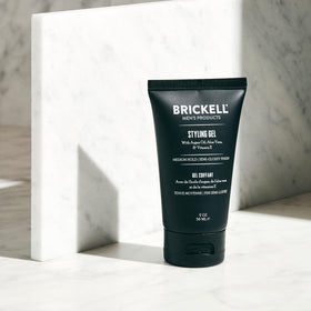 Brickell Men's Products jar held in hand to show compact travel-friendly scale