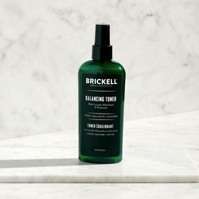Brickell Men's Products toner in use applied with cotton pad to refresh skin and reduce shine